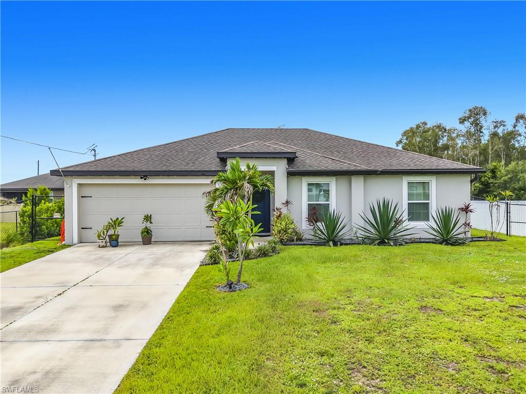 Contemporary stucco exterior featuring a dark asphalt shingle roof