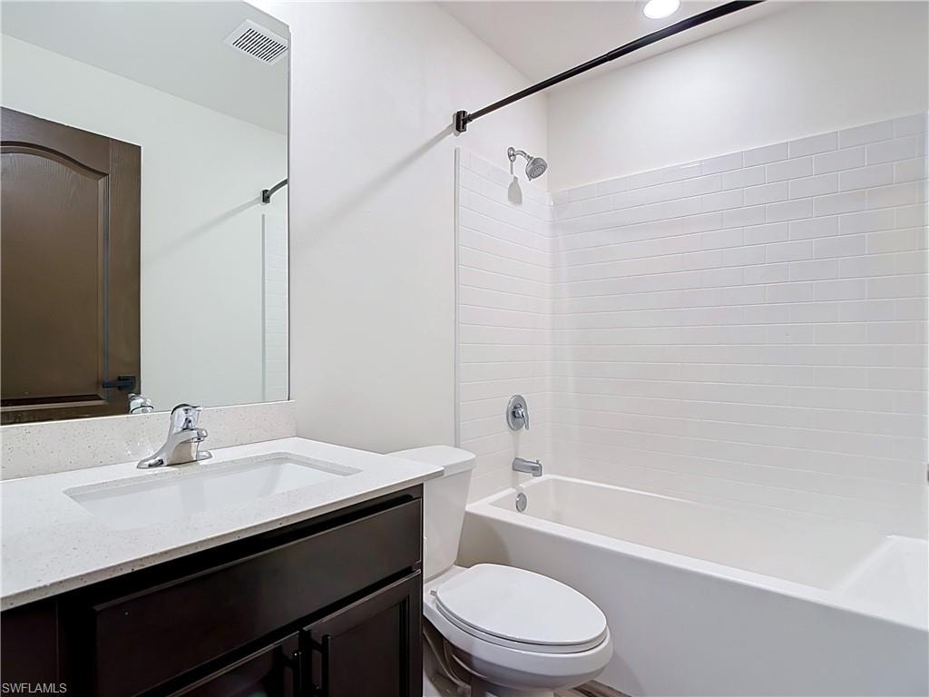Full bathroom featuring a dark wood-finish vanity with a light-toned countertop and an integrated sink