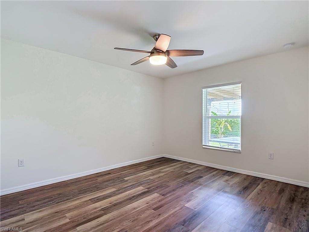 Room featuring wood-finish flooring, white baseboards, a single window with horizontal blinds, and a ceiling fan with integrated lighting
