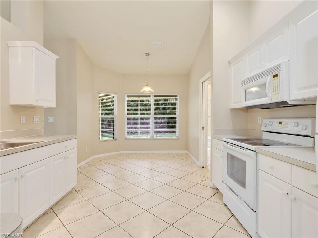 Kitchen with White Cabinetry, Tile Flooring, & Eat In Kitchen with Bay Window