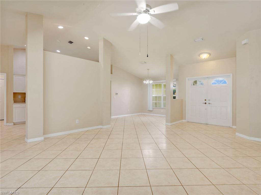 Living Room with Tile Flooring, Vaulted Ceiling, Ceiling Fan & Dining Room
