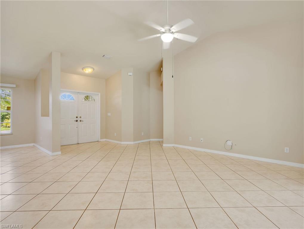 Entry Foyer, Living Room with Tile Flooring, Vaulted Ceiling, Sliders to the Screened In Lanai, & Ceiling Fan