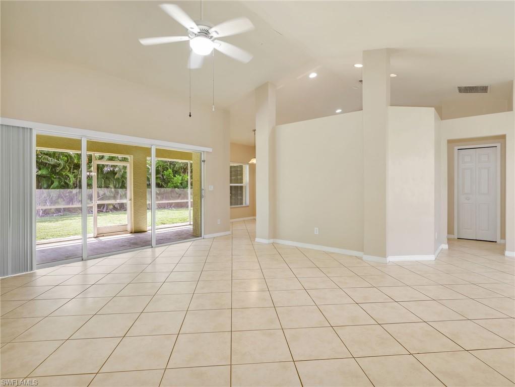 Living Room with Tile Flooring, Vaulted Ceiling, Sliders to the Screened In Lanai, & Ceiling Fan