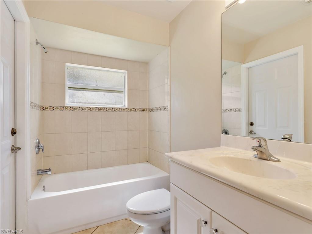 Second Bathroom with Tiled Shower/Tub Combo & White Cabinetry