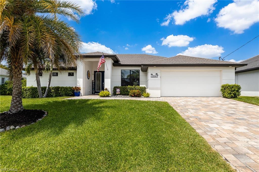 Single-story residence featuring a paver driveway, an attached two-car garage, and a covered front entry