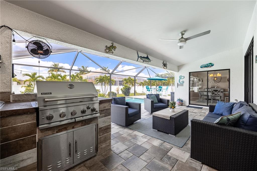 Screened lanai featuring a built-in outdoor kitchen with stainless steel grill, stone-finish countertop, and integrated cabinetry