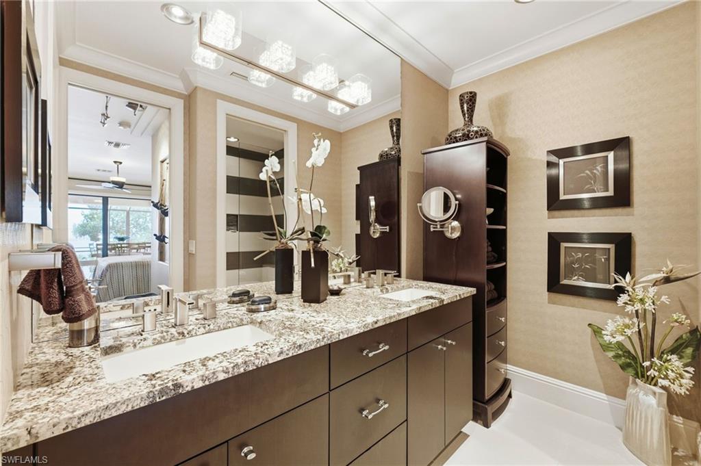 The fifth ensuite bath showcases refined elegance with dual granite countertops, custom wood cabinetry, and a private water closet. The walk-in shower features a unique Listello accent, adding a distinctive designer touch to this luxurious retreat.