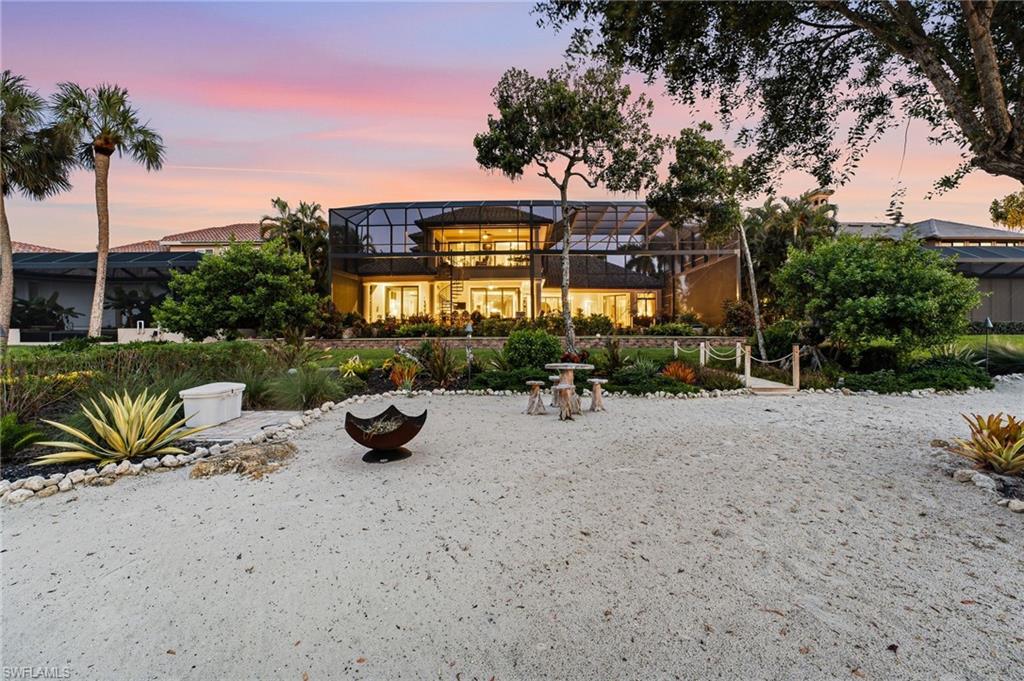 The landscaped private beach offers a serene and spectacular vantage point overlooking the rear of the residence, showcasing its striking architecture and exceptional waterfront setting.
