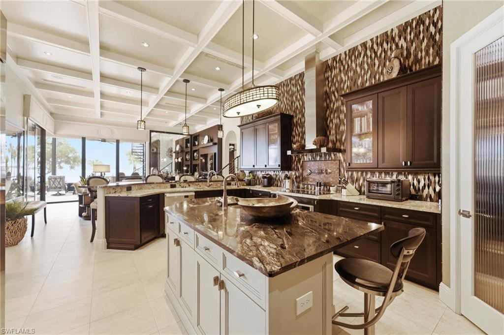 The centerpiece of this extraordinary kitchen is its magnificent marble-topped island, complemented by a beautifully appointed bar with ample seating—an inviting setting where family and friends can gather, entertain, and create unforgettable memories.