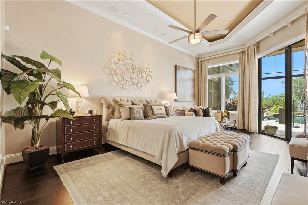 The waterfront primary suite is a private sanctuary, offering direct access to the lanai, elegant wood flooring, a double tray ceiling with ambient uplighting, and walls of glass that fill the room with natural light. Wake each morning to breathtaking river views and the tranquil beauty of the waterfront.