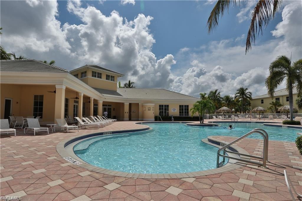 Expansive pool area featuring a free-form swimming pool, integrated shallow entry, and surrounding paver decking