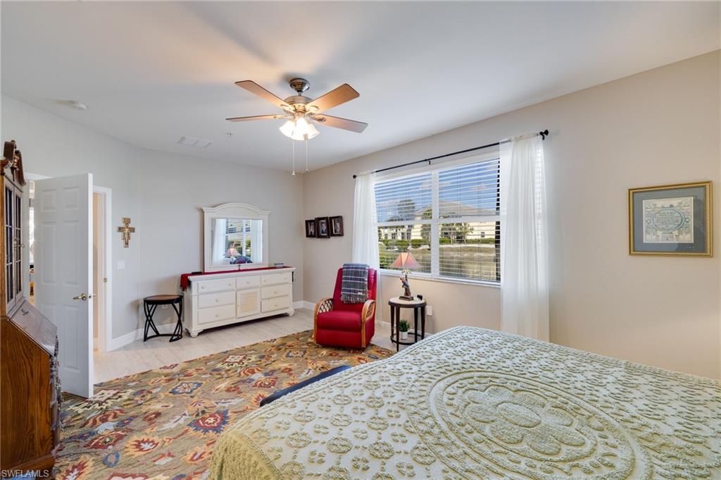 Spacious room featuring a ceiling fan, large window with horizontal blinds, and light-toned wall paint