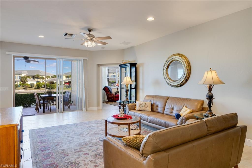 Sliding glass doors leading to an outdoor patio with a dining set, ceiling fan, recessed lighting, and tiled flooring