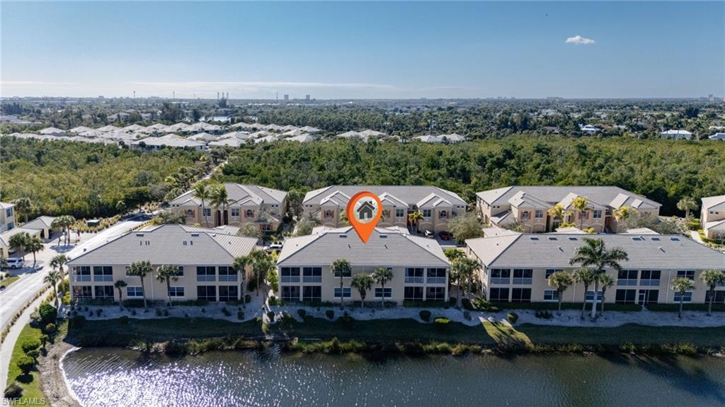 Waterfront property with multiple residential buildings, surrounded by lush landscaping and mature palm trees