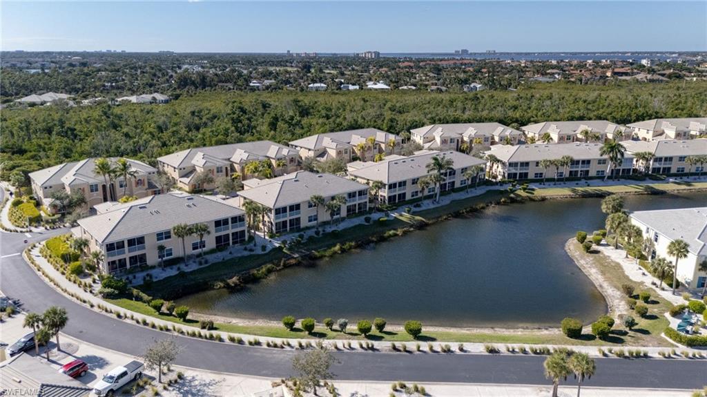 Waterfront community with multiple residences, surrounding natural landscaping, and a manicured streetscape