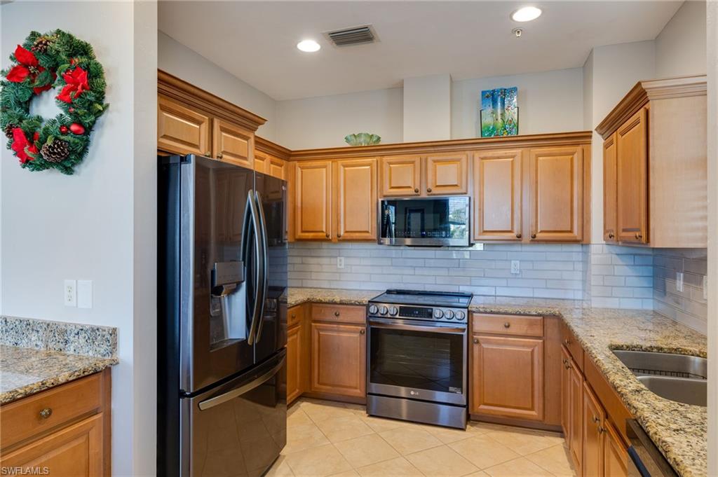 Full kitchen featuring wood cabinetry, stainless steel appliances, granite countertops, tile backsplash, and recessed lighting