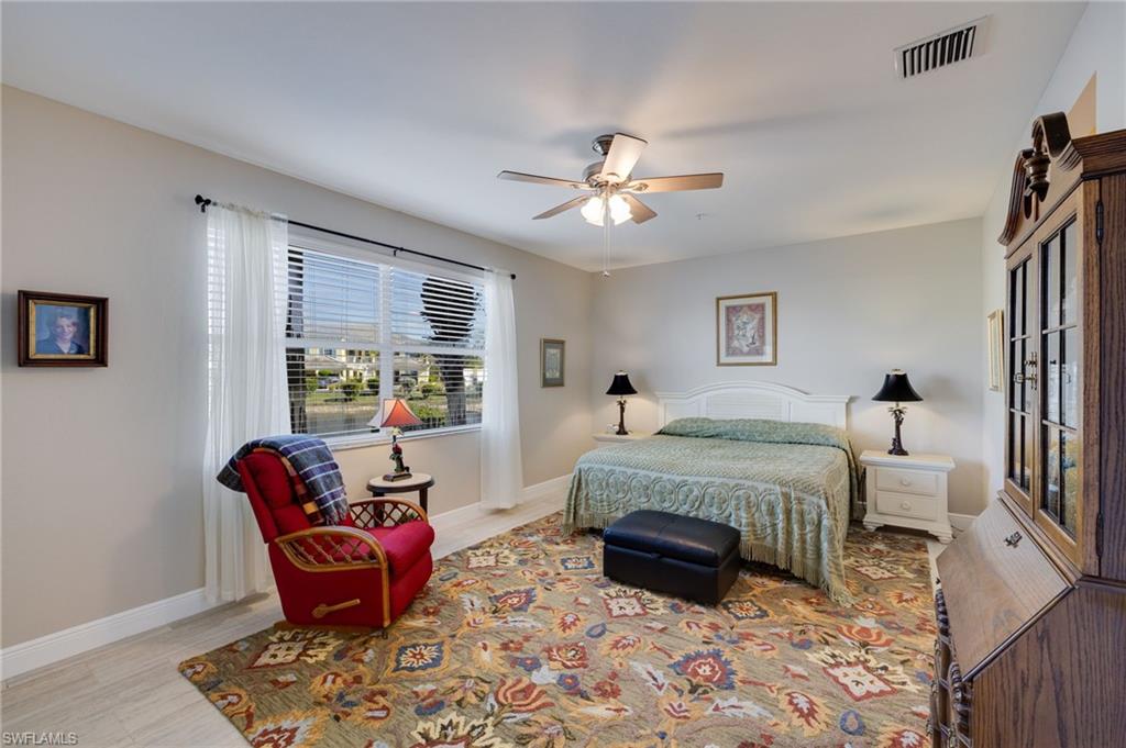 White headboard with nightstands, ceiling fan, and large window with blinds