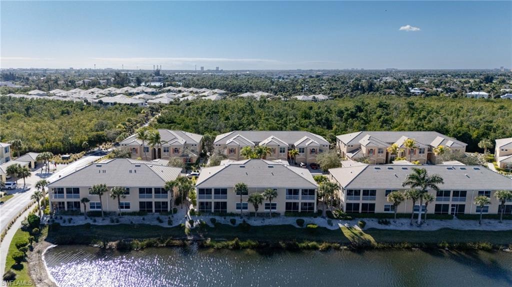 Waterfront community with multiple residential buildings, private balconies, and mature palm trees