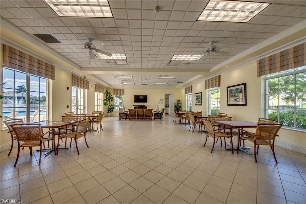 Spacious common area featuring tile flooring, multiple ceiling fans, and recessed lighting