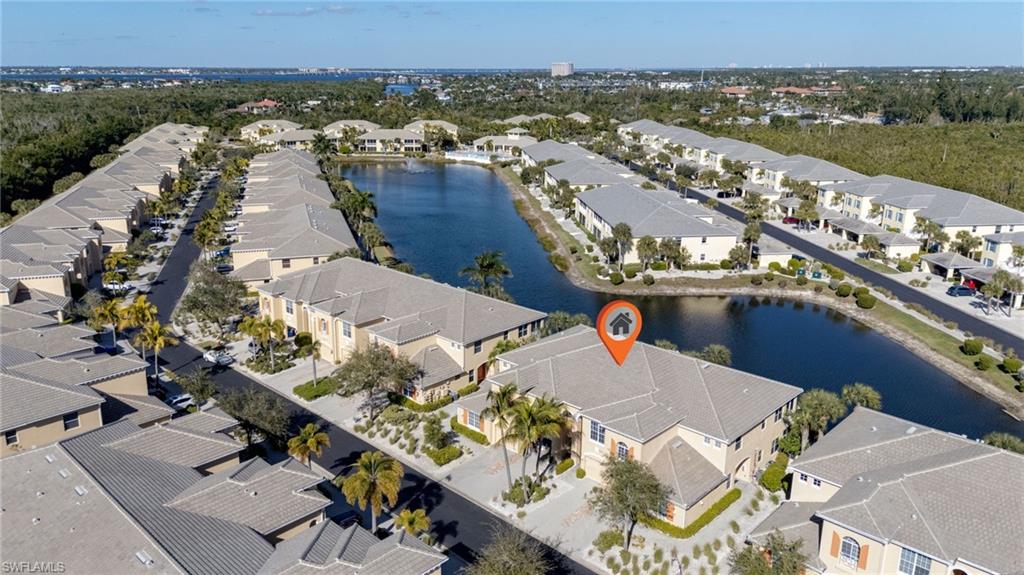 Aerial perspective showcasing the property among rows of townhomes, a prominent water feature, and mature landscaping