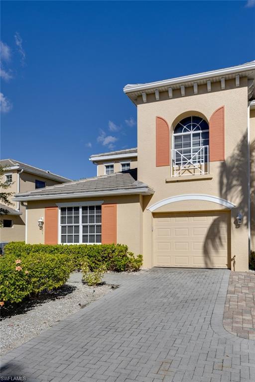 Mediterranean-inspired exterior with a stucco finish, arched window, and decorative shutters