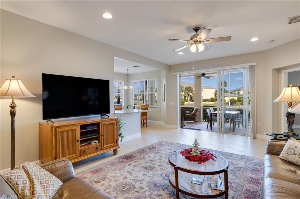 Tiled flooring throughout, recessed lighting, ceiling fan, sliding glass doors to outdoor patio, and a breakfast bar with pendant lighting