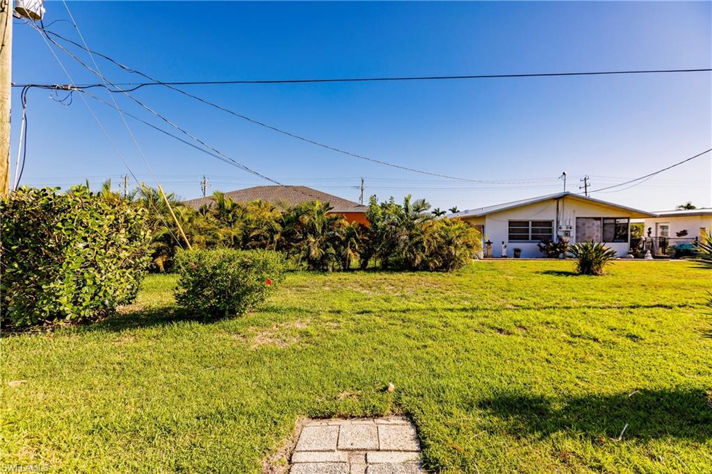 Expansive green lawn with established shrubbery and mature tropical plantings