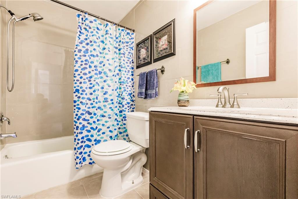Bathroom vanity with a light-toned countertop, undermount sink, and brushed nickel faucet