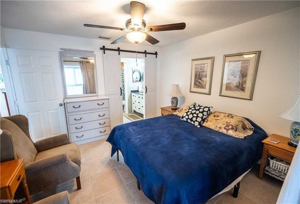 Spacious room featuring tile flooring, a ceiling fan with integrated lighting, and white walls