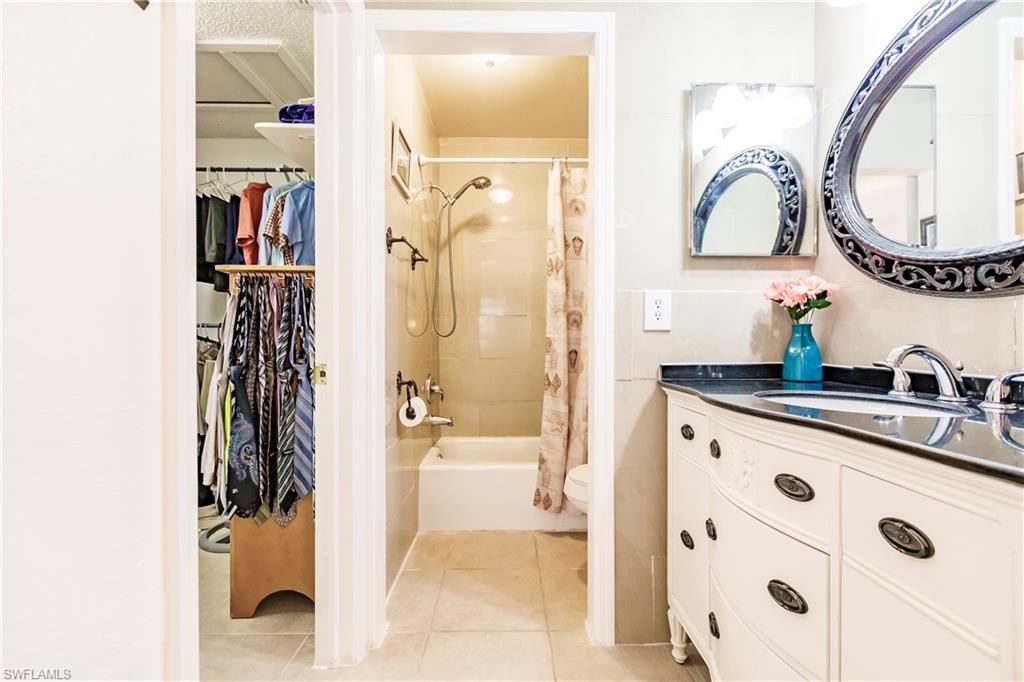 Bathroom featuring a curved vanity with a dark countertop and chrome faucet