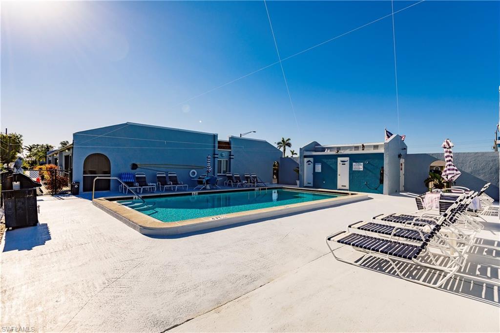 Outdoor swimming pool featuring a ladder entry and surrounding concrete deck