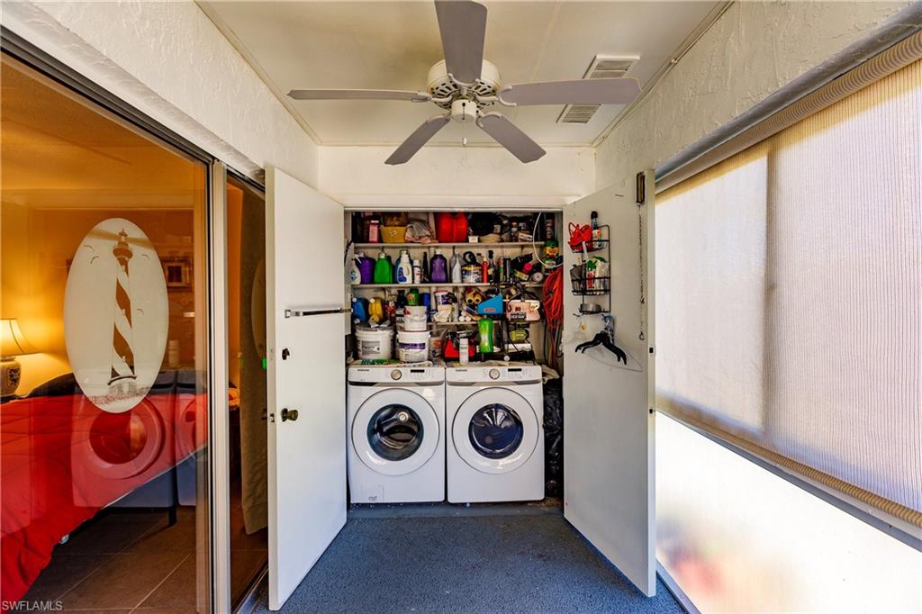 Dedicated laundry area featuring a stacked washer and dryer, integrated shelving, and a ceiling fan