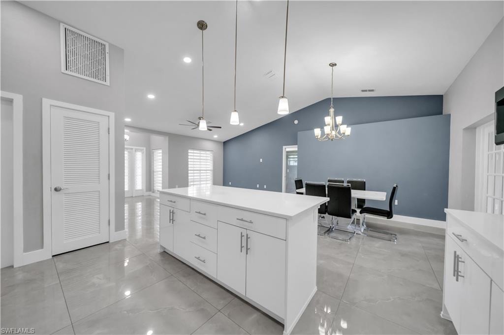 White kitchen island with quartz countertop and pendant lighting
