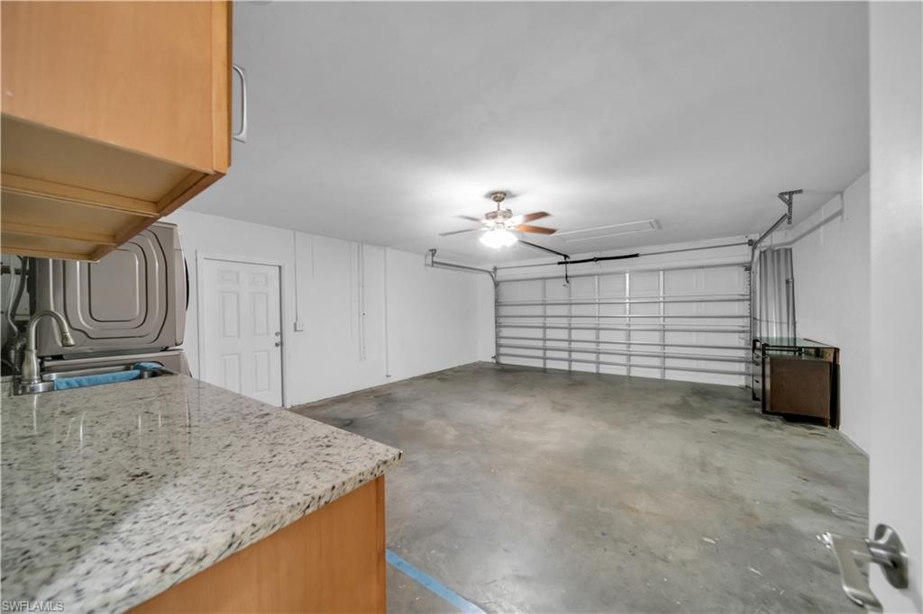 Spacious garage with a concrete floor, ceiling fan, and overhead lighting