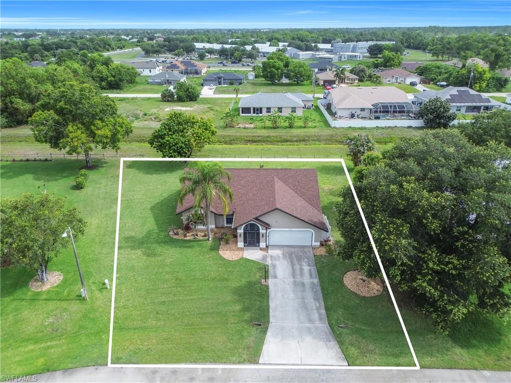 Single-story residence with an attached two-car garage, mature landscaping, and a concrete driveway