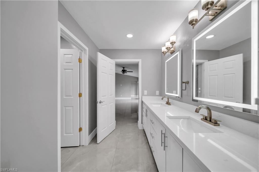 Dual vanity with integrated sinks, quartz countertops, brushed nickel fixtures, and illuminated mirrors
