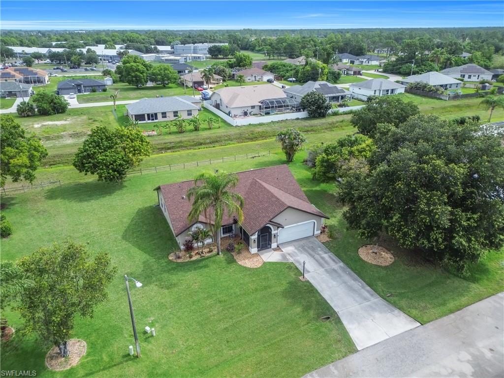 Single-story residence featuring a two-car garage, concrete driveway, and mature landscaping
