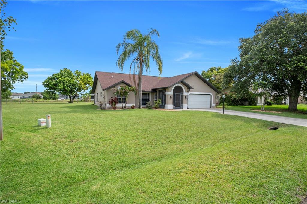Single-story residence featuring a covered entry, attached two-car garage, and a paved driveway