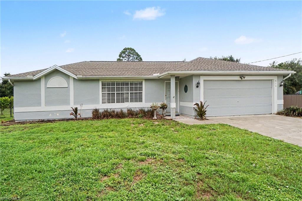 Ranch-style residence featuring a light gray exterior with white trim, a brown shingle roof, and an attached two-car garage