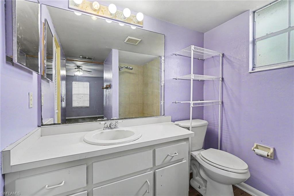 Single vanity with an integrated sink, white countertop, and under-sink cabinetry