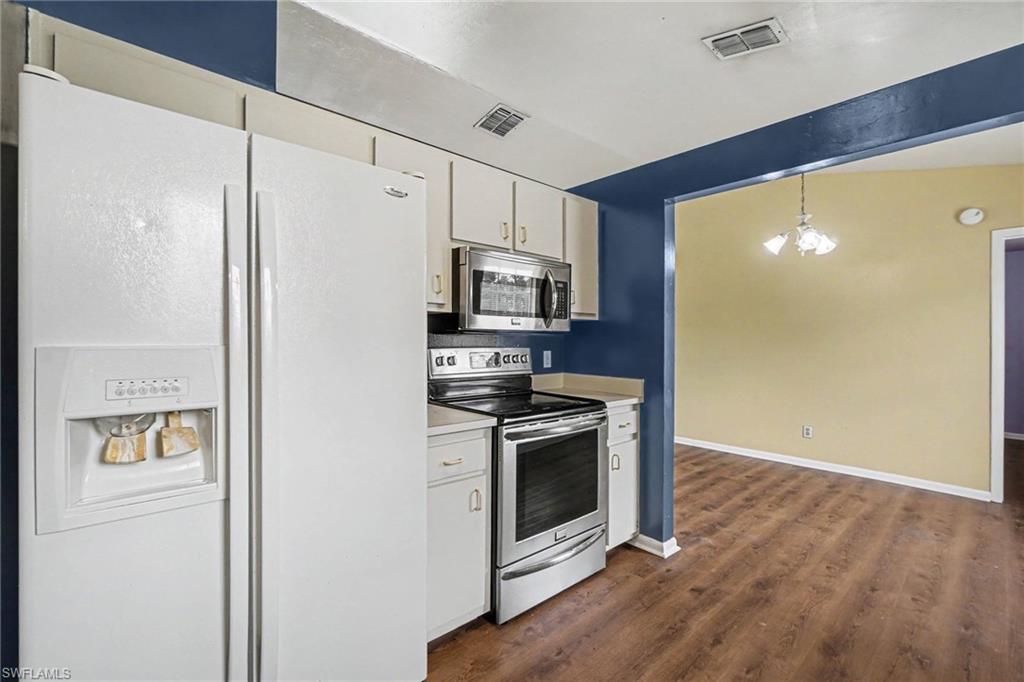 Kitchen featuring white cabinetry and wood-finish flooring