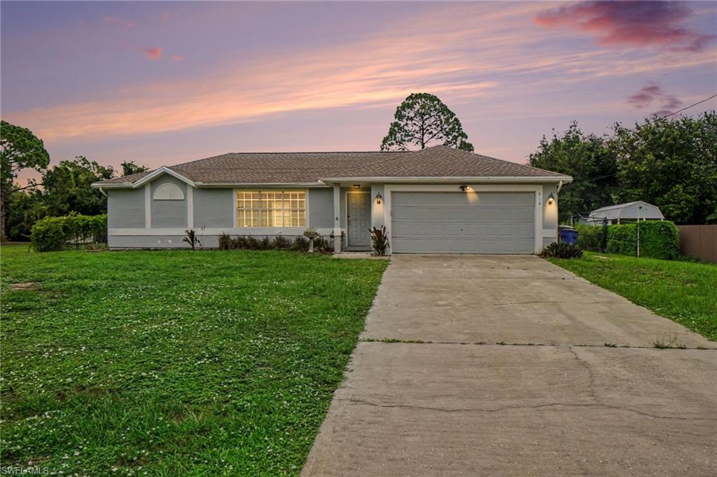 Single-story residence featuring a two-car garage, concrete driveway, and a shingle roof