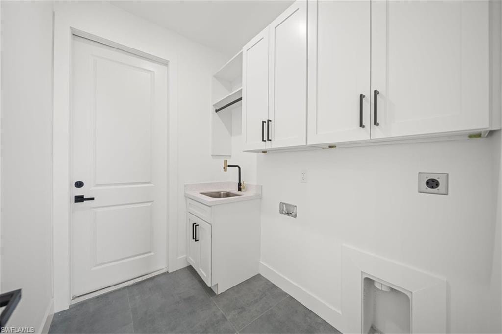 Laundry room featuring custom upper cabinetry for added storage