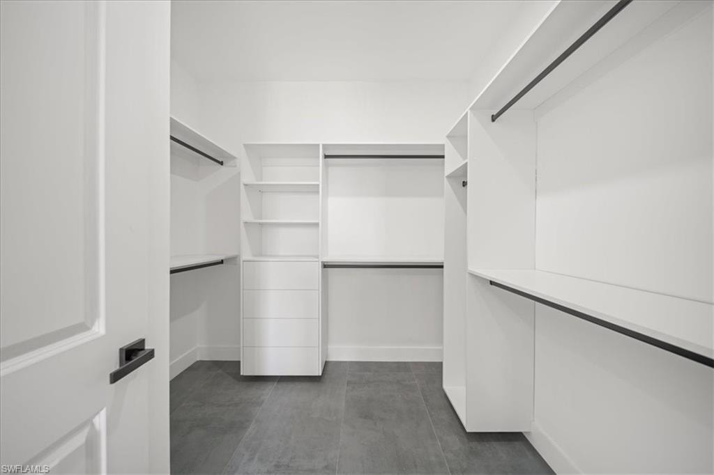 The expansive closet offers built-in shelving, drawer storage, and abundant hanging space, creating a clean and functional luxury wardrobe experience.