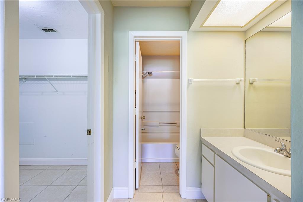 Built-in vanity with an integrated sink, polished chrome faucet, and expansive wall-mounted mirror