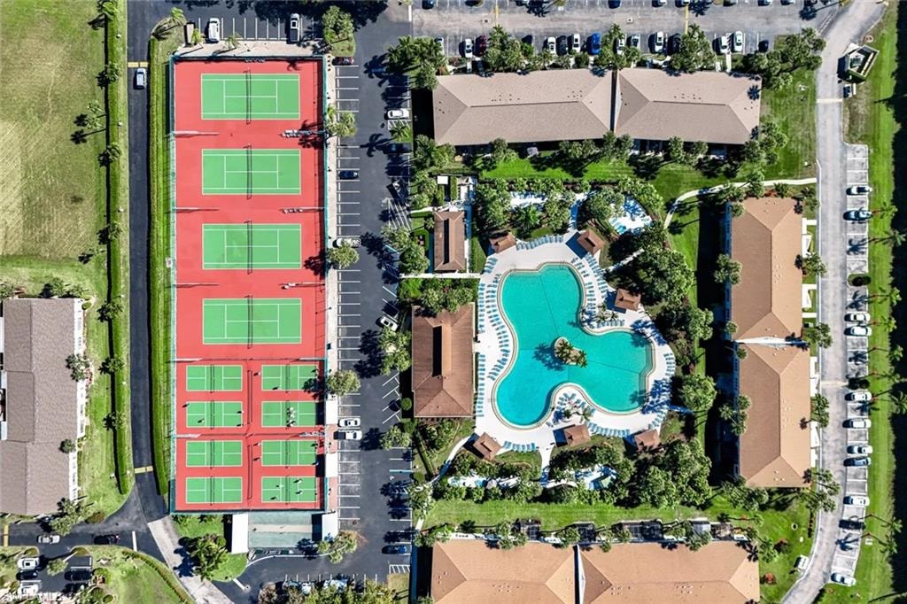 Tennis courts with multiple playing surfaces, expansive swimming pool, and dedicated parking areas