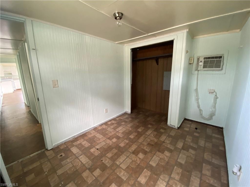 Unfurnished bedroom with dark tile patterned flooring, a closet, and a wall mounted air conditioner