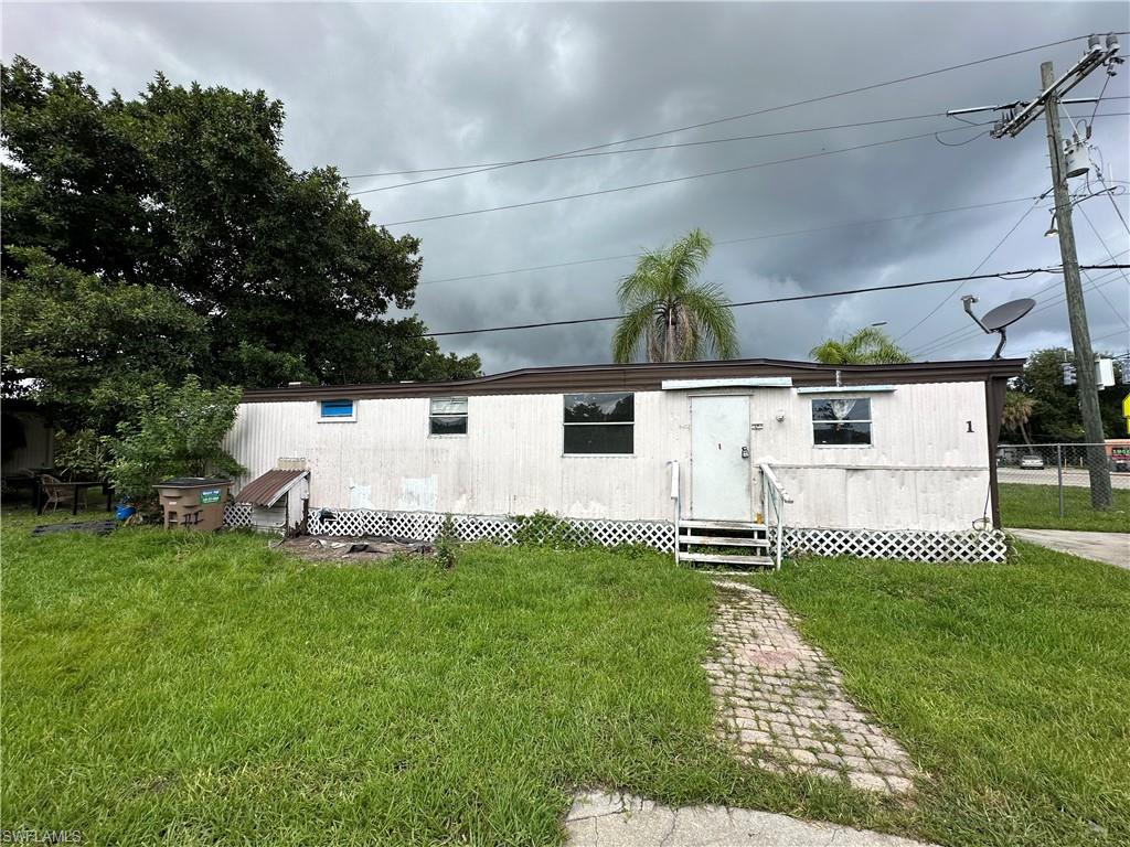 Back of property with a lawn
