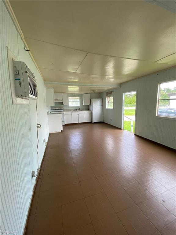 Unfurnished room featuring dark tile patterned flooring and an AC wall unit