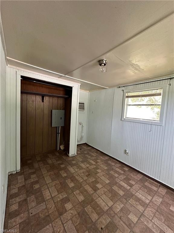 Unfurnished bedroom featuring dark tile patterned flooring, a closet, and a wall unit AC